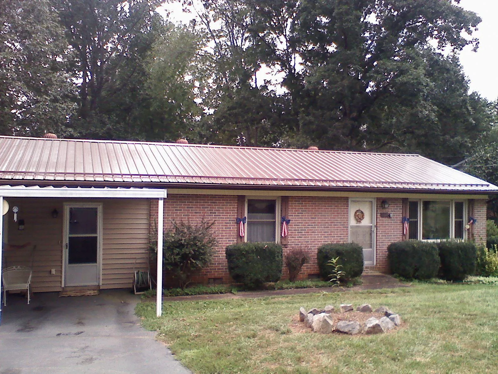 Bronze metal roof and carport on a brick ranch home — Roof Repair work by our crew in Davey